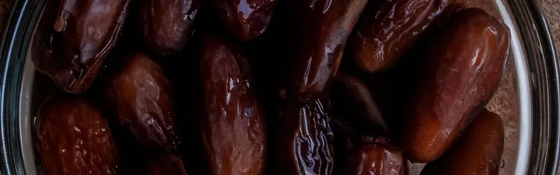 Dattes dans un bol en verre sur une table en bois